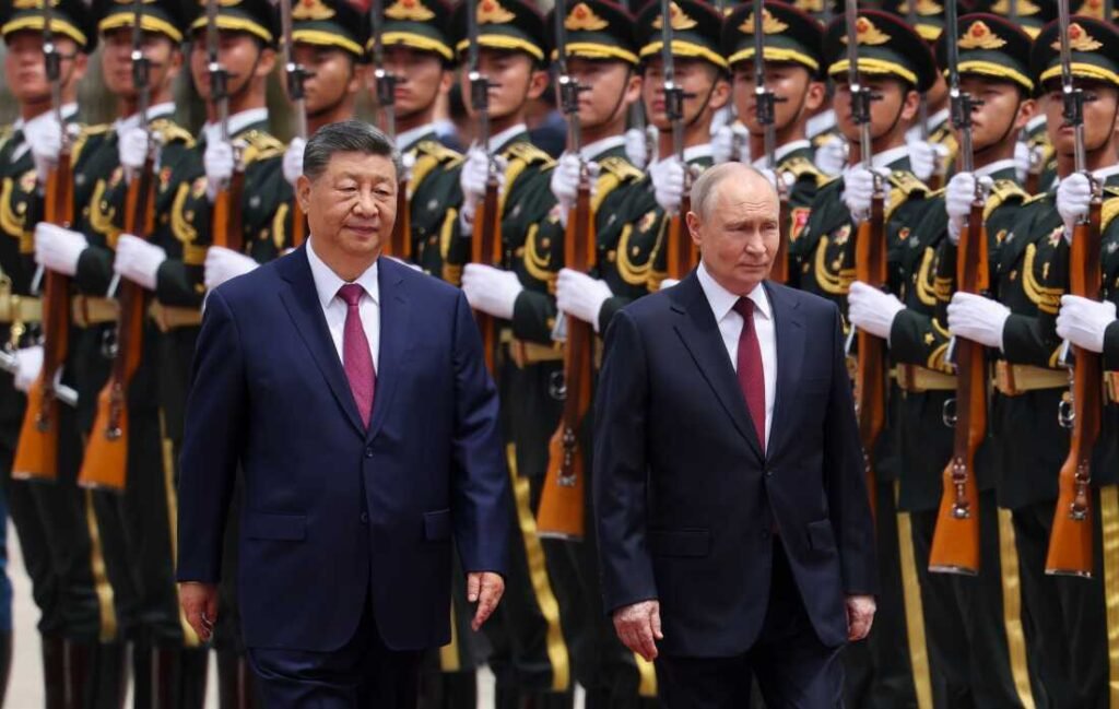 Chinese President Xi Jinping and Russian President Vladimir Putin walk side-by-side past a military honor guard, providing a formal visual backdrop for a geopolitical analysis of the Putin-Xi Summit.