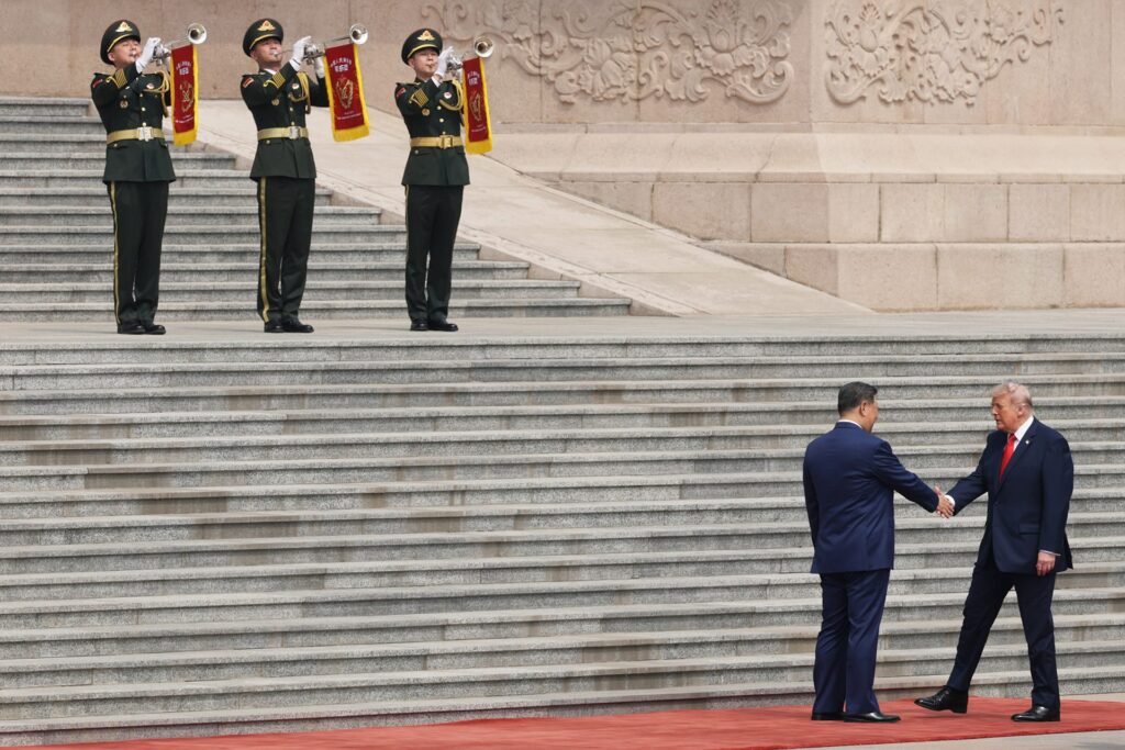 China and the U.S. Agreed to ‘Strategic Stability’ in Beijing. They Don’t Define It the Same Way Chinese President Xi Jinping and U.S. President Donald Trump shake hands on a red carpet in Beijing during a military welcome ceremony with horn players, highlighting the complex diplomatic engagement behind strategic stability.