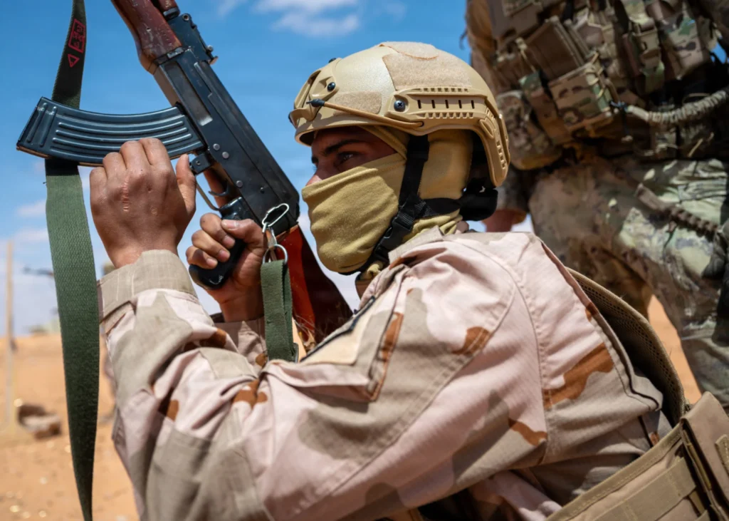 گزارش از لیبی: چرا ایالات متحده به تعهدی تازه در مبارزه با تروریسم در آفریقا نیاز دارد A soldier in desert camouflage and a tactical helmet holding a rifle during a training exercise, illustrating the security cooperation and military partnerships that define the current US Africa strategy for regional stability.