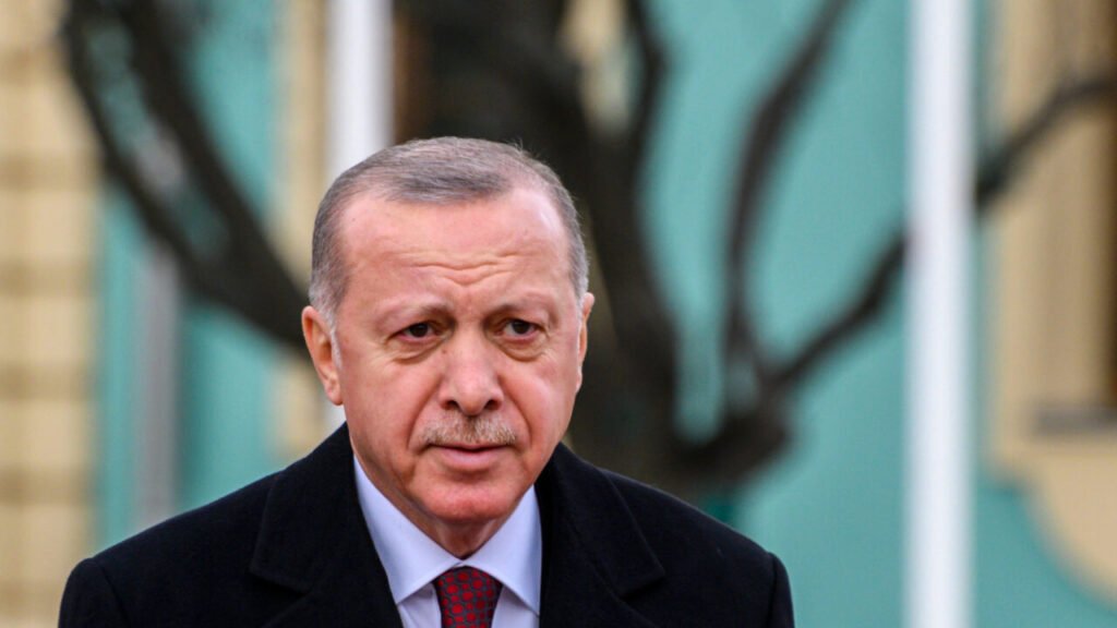 Recep Tayyip Erdogan’s ‘Decapitation Strike’ on Turkey’s Opposition Party A close-up portrait of Turkish President Recep Tayyip Erdogan looking forward thoughtfully against a soft-focused teal background, capturing the central political figure behind Recep Tayyip Erdogan’s ‘decapitation strike’ on Turkey's opposition party.
