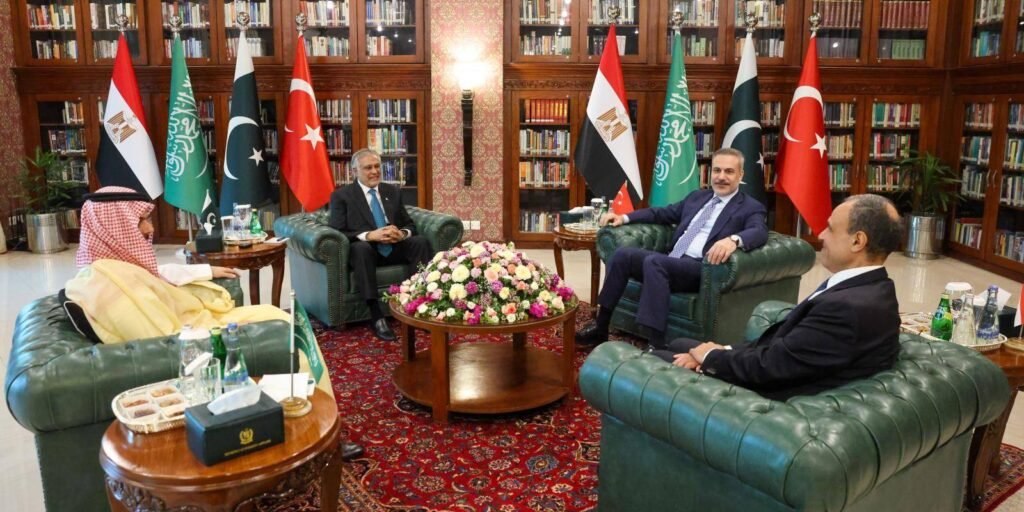 Foreign ministers from Egypt, Pakistan, Saudi Arabia, and Turkey sit in a formal diplomatic reception room in Islamabad, lined with national flags, engaged in multilateral discussions aimed at regional de-escalation and resolving the Iran war.