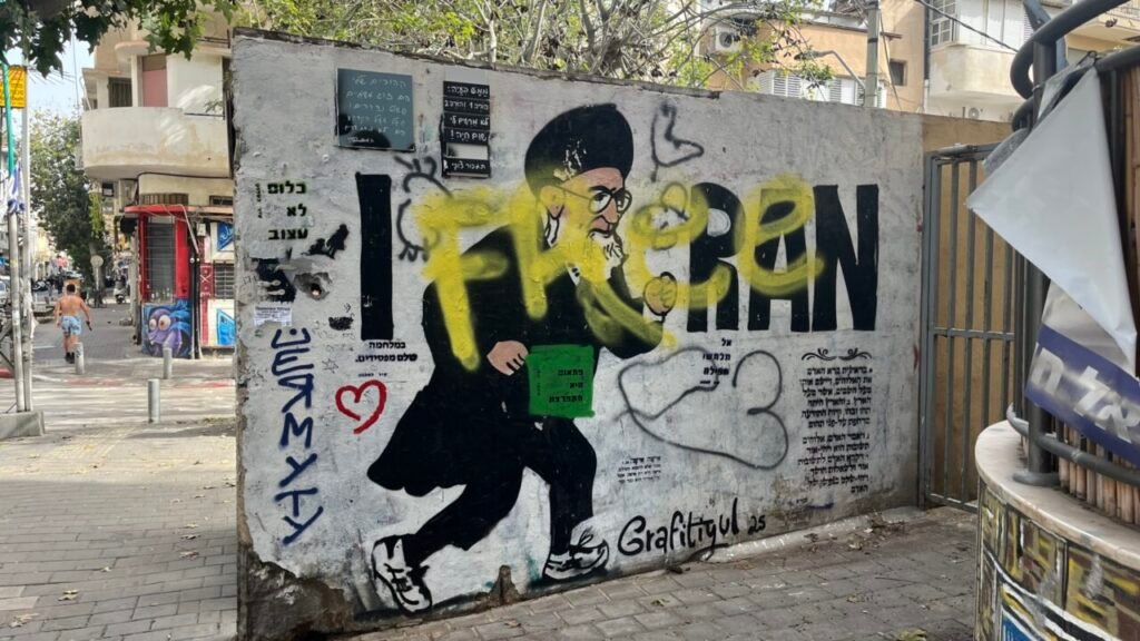 حروب نتنياهو غير المكتملة: كيف يمكن لأوروبا إيقاف الجولة القادمة Anti-regime street graffiti on a concrete wall in Tel Aviv depicting a caricature, with the urban sidewalk in the background contextualizing the political dissent and societal pressure surrounding Netanyahu’s unfinished wars.