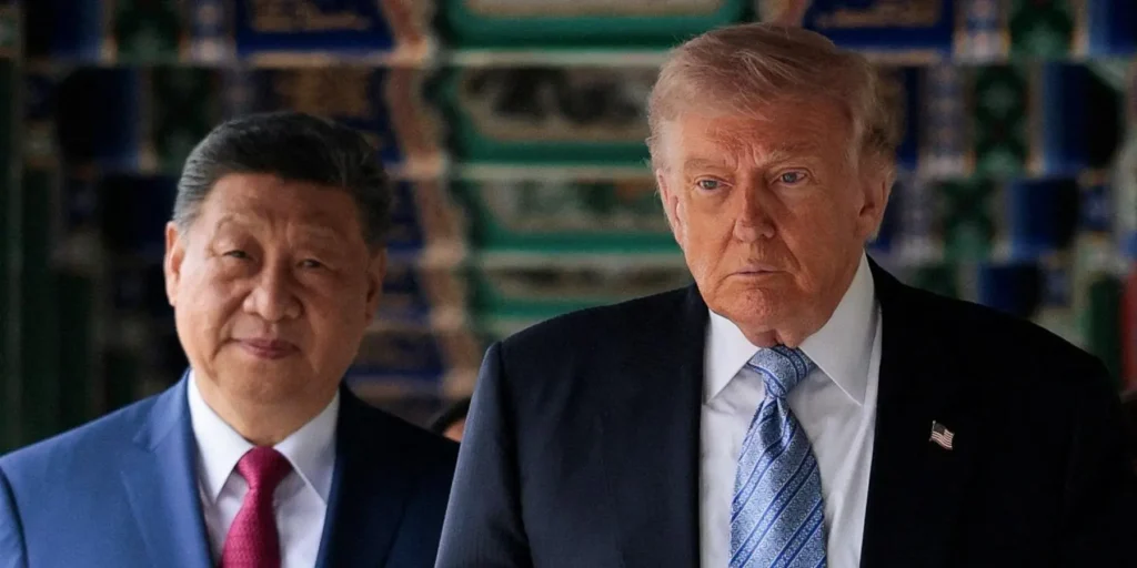 China’s position on the Hormuz Strait: What ‘open’ really means Donald Trump walks forward with a serious expression ahead of a smiling Xi Jinping, set against a traditional patterned backdrop, framing the competing geopolitical interests that define China position on Hormuz Strait.