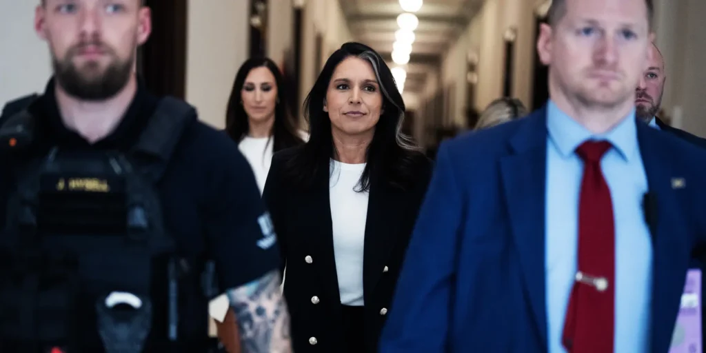 Former US Representative Tulsi Gabbard walks confidently through a brightly lit hallway flanked by security personnel and aides, serving as a visual centerpiece for a political commentary on a strategic Trump exit.