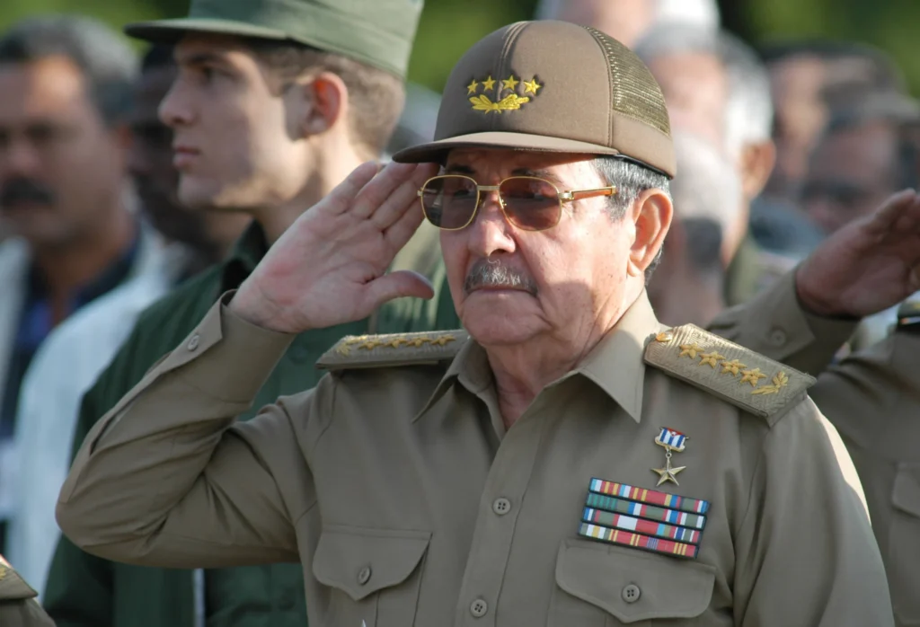After the Castro indictment, what is Trump’s endgame in Cuba? Former Cuban President Raul Castro in a military uniform and cap salutes during an official event, providing historical context for a policy analysis on Trump's endgame.