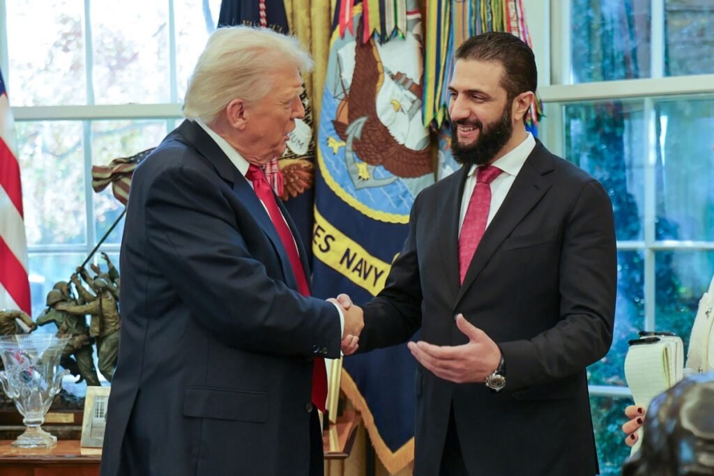 Why Syria-US ties cannot rely on leaders’ personal chemistry US President Donald Trump shaking hands with Syrian President Ahmed al-Sharaa at the White House, serving as the central visual analysis of why institutional Syria-US ties cannot rely on leaders’ personal chemistry.