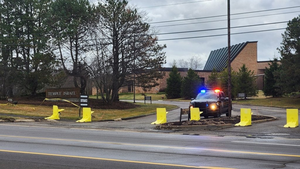 Between Intent and Capability: Assessing the Lack of Iranian Attacks on the U.S. Homeland A police vehicle with flashing lights stationed behind yellow security barriers at the entrance of Temple Israel, representing heightened security measures in response to potential Iranian homeland plots and regional threats.