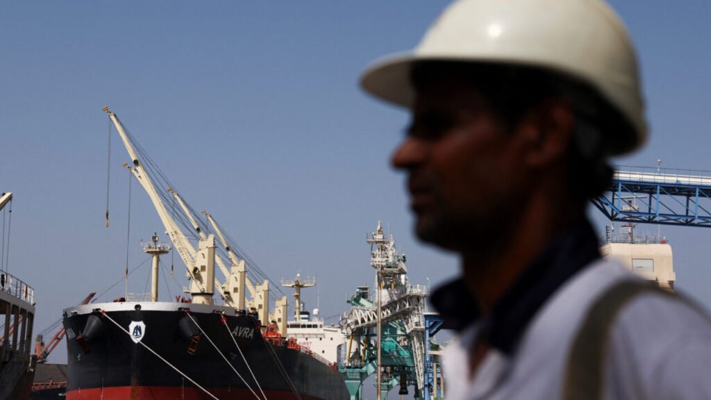 The bulk carrier vessel 'Avra' docked at the Port of Fujairah with cargo cranes in the background, serving as a visual case study for bypassing the straits and redesigning the India-Middle East-Europe corridor during wartime.