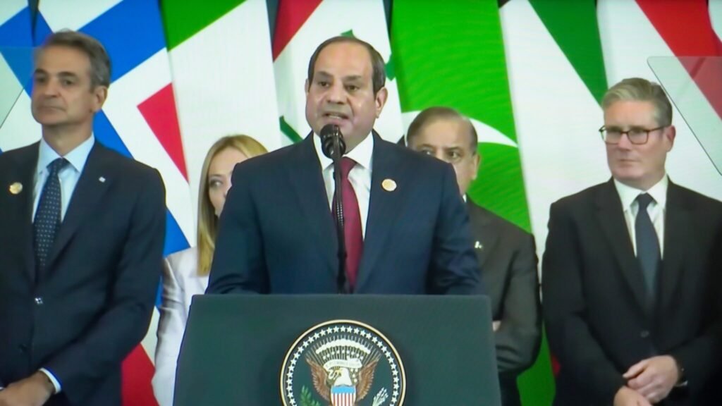 Is Egypt the Biggest Loser of the Iran War? Egyptian President Abdel Fattah el-Sisi speaks at a podium with the Seal of the President of the United States, flanked by international leaders and flags, illustrating the geopolitical pressures positioning Egypt the Biggest Loser in regional diplomatic fallout.
