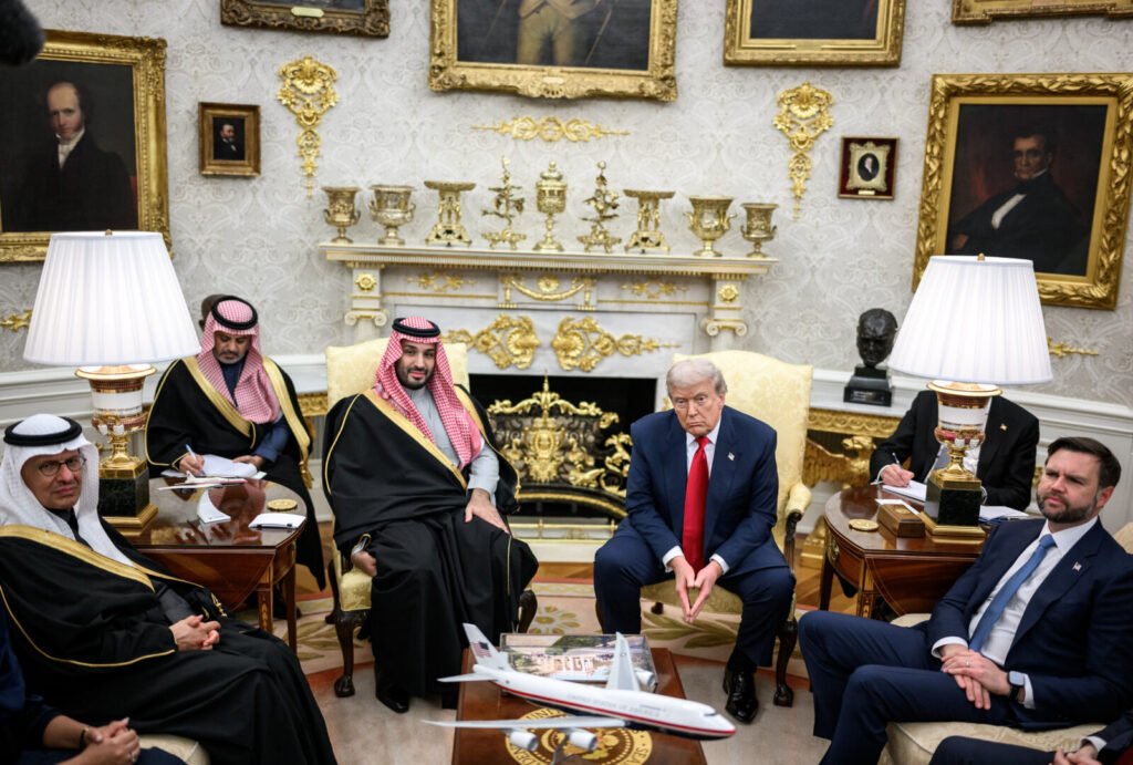 Donald Trump and Saudi Crown Prince Mohammed bin Salman seated in the Oval Office with advisors, illustrating a high-stakes diplomatic meeting centered on the strategic partnership and the complex process of reassessing reliance on US security in the Gulf region.
