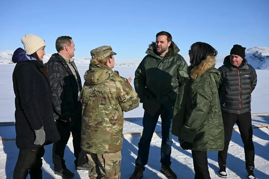 Vice President JD Vance and second lady Usha Vance standing in heavy winter jackets alongside military personnel on a snowy field at Pituffik Space Base in Greenland, providing geographical context to the discussions surrounding Trump's Iran diplomatic strategies.
