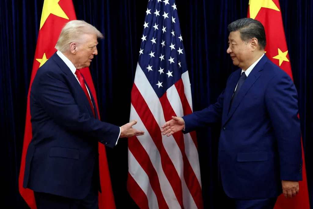 Donald Trump and Xi Jinping reaching out for a handshake in front of the American and Chinese flags, symbolizing the critical diplomatic stakes of the U.S.-China Summit and the Beijing Talks.