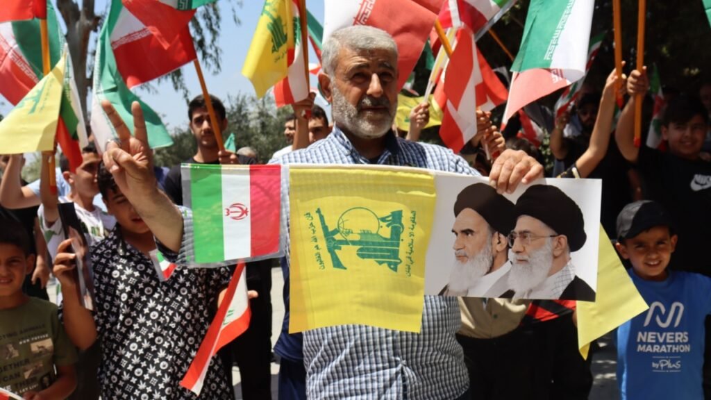 Iranian and Hezbollah supporters waving flags and portraits of Iranian leaders during a public rally, illustrating the ideological backing that enables Hezbollah West Africa financial networks to thrive across multiple regions.