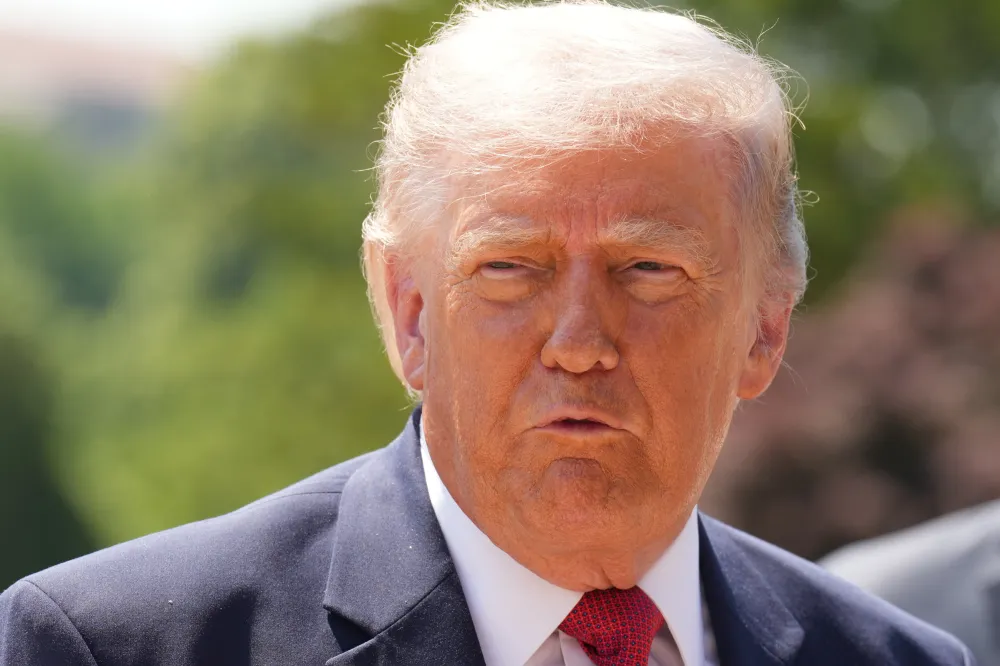 King Trump and the Looming MAGA Challenge A direct outdoor close-up of Donald Trump looking forward with a serious facial expression against a soft-focus natural green background, underscoring the intense political scrutiny surrounding the narrative of King Trump.