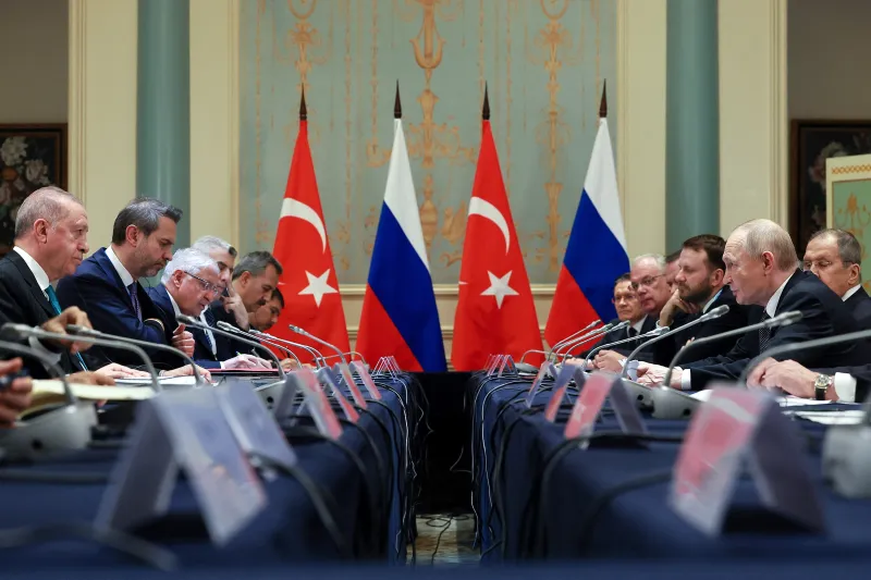 Turkey’s Quiet Realignment Turkish President Recep Tayyip Erdogan and Russian President Vladimir Putin lead their respective delegations across a long conference table lined with Turkish and Russian flags, visually highlighting the diplomatic engagement behind Turkey's Realignment.