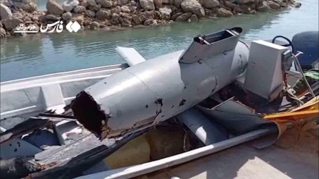 حلفاء متباينون: هل تدفع إسرائيل أمريكا نحو صراع لا نهاية له مع إيران؟ A large gray military projectile with structural damage sits inside a small vessel docked along a rocky coastline, offering a stark physical example of the tactical escalations that risk fueling an endless conflict with Iran.