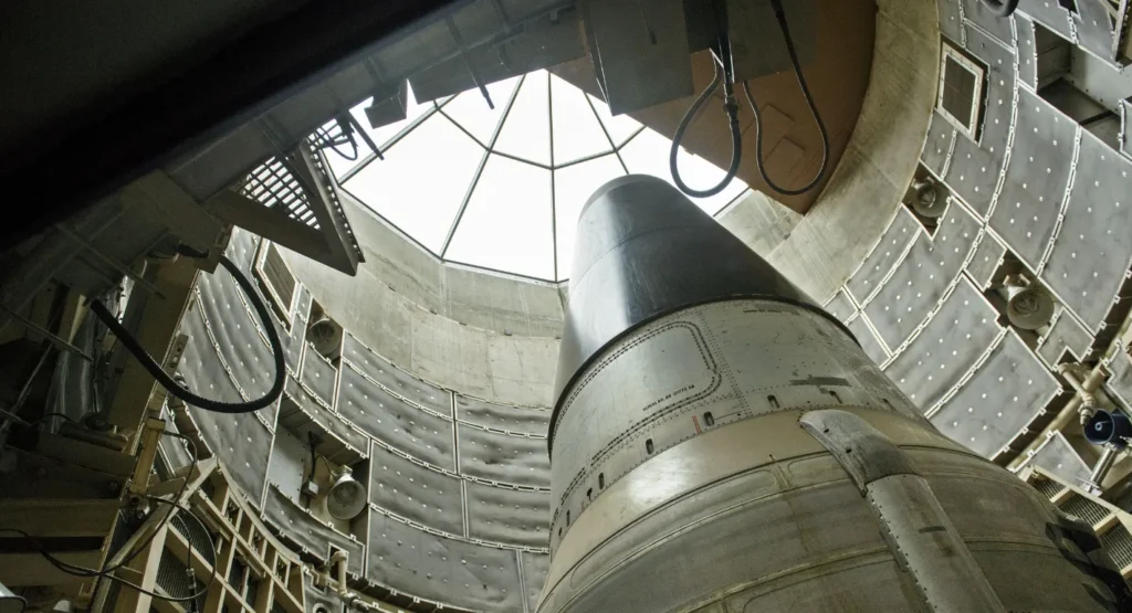 Europe Should Not Let Nuclear Nonproliferation Die A low-angle view looking up inside a concrete military silo at a massive ballistic missile pointed toward an open skylight, emphasizing the strategic defense realities underlying the push to ensure Europe should not let nuclear nonproliferation die.