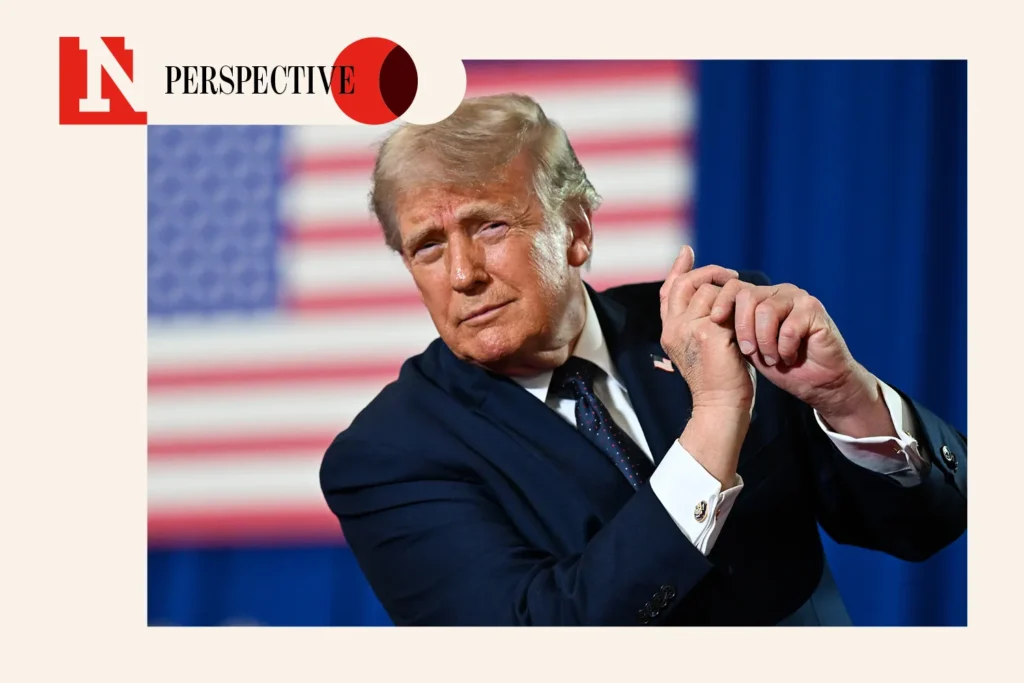 5 Numbers That Defy the Trump Economy Doomers U.S. President Donald Trump gesturing with clasped hands on stage in front of an American flag backdrop during an economic policy speech, illustrating the political discourse surrounding the Trump economy.