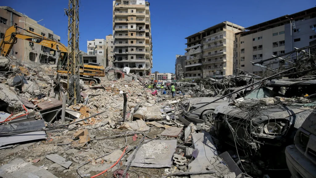 How Hezbollah rebuilt itself for a war of attrition with Israel Emergency rescue personnel and excavators work amidst severe structural destruction on a debris-filled street in Tyre, highlighting the real-world devastation caused by a prolonged war of attrition.