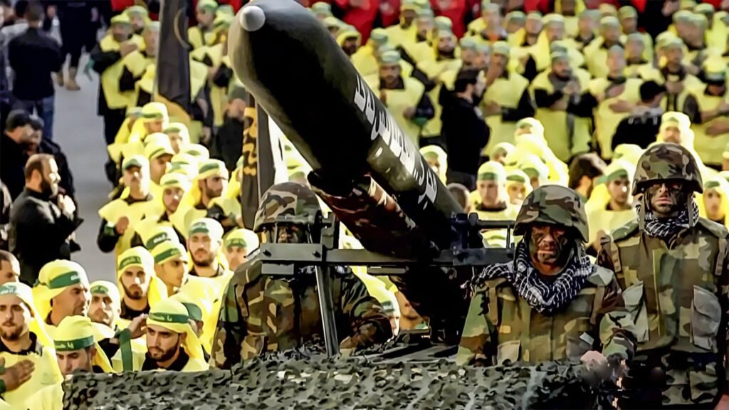 Armed soldiers in camouflage stand before a large military rocket on a launcher during a Hezbollah military parade in Beirut, Lebanon, visually demonstrating the proxy capabilities linked to Iran's New Strategic Doctrine.