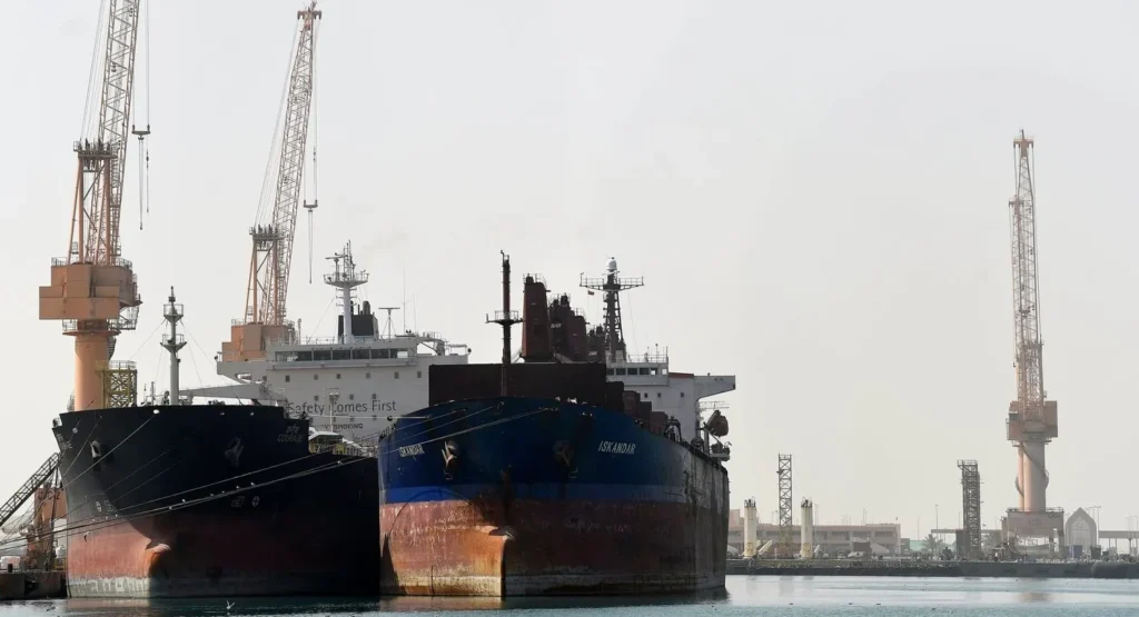Duqm at the Crossroads: Oman’s Strategic Port and Its Role in Vision 2040 Large cargo ships named Iskandar and Courage dock at a commercial port terminal surrounded by tall industrial shipping cranes, illustrating the maritime infrastructure central to the economic development of Duqm.