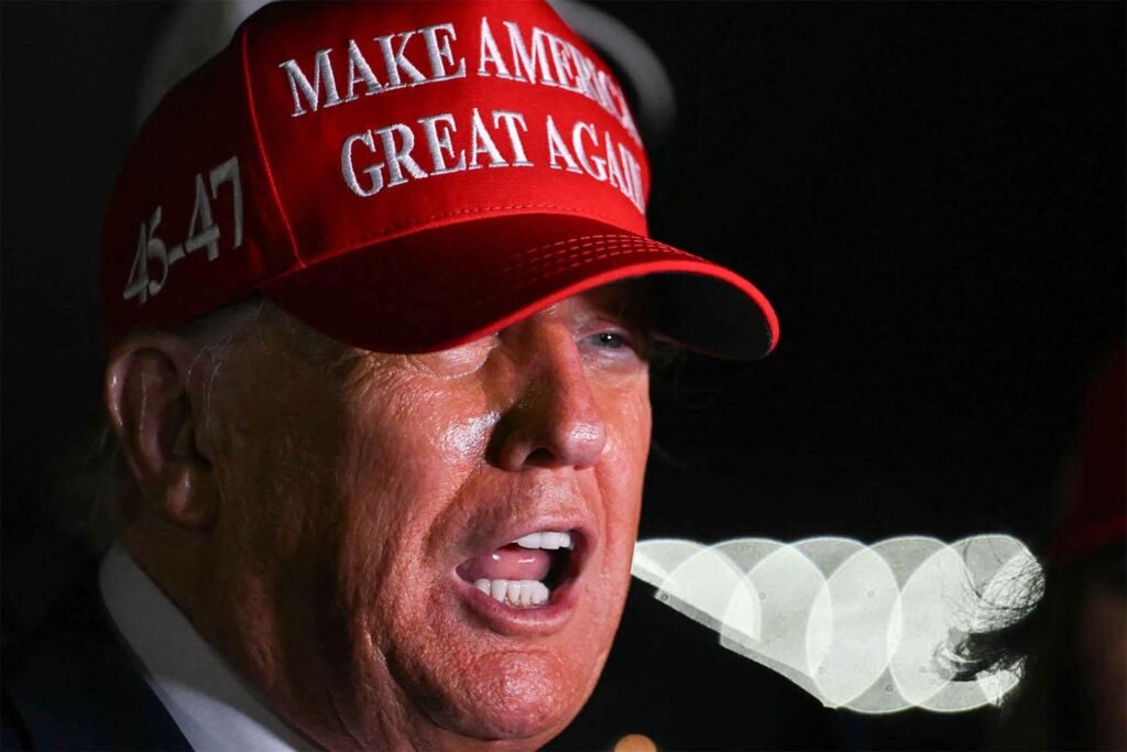 A close-up shot of Donald Trump speaking outdoors while wearing a bright red "Make America Great Again" cap, capturing a moment of intense political rhetoric linked to shifts from a respected hegemon.