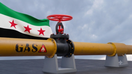 A close-up view of a yellow industrial pipeline labeled "GAS" with a prominent red valve wheel, set against a Syrian flag waving in the background under a cloudy sky, illustrating regional energy infrastructure dynamics relevant to Israeli gas exports.