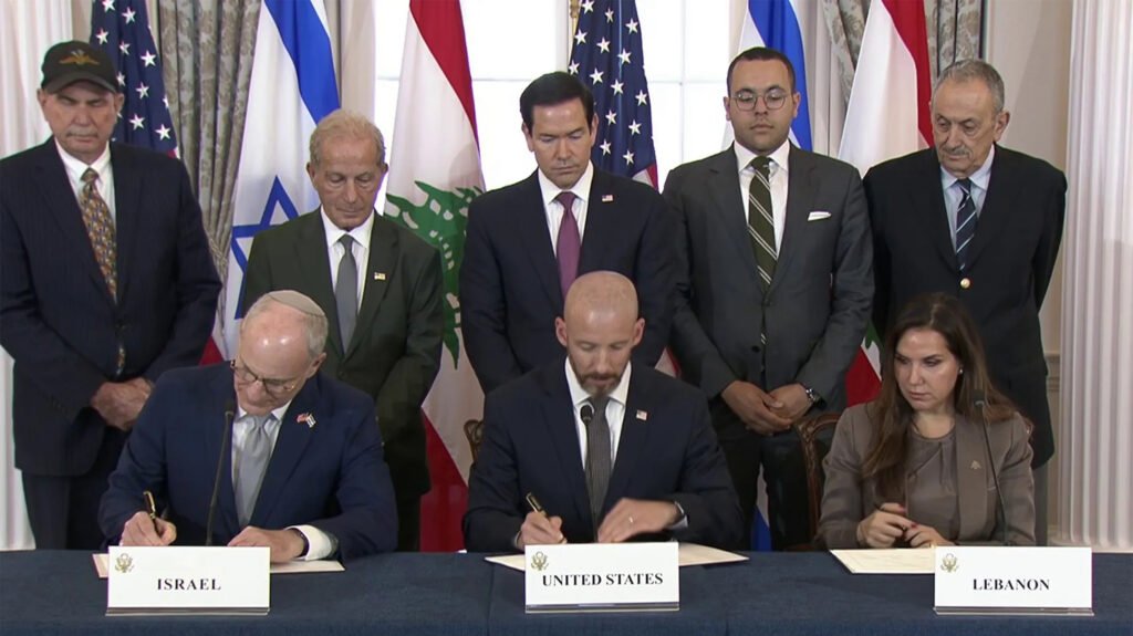 The Lebanese-Israeli Framework Agreement: Limits to Implementation Officials from Israel, the United States, and Lebanon sit at a formal table signing documents under their respective country nameplates, while delegations stand behind them with national flags on display, illustrating the diplomatic moment of the Framework Agreement.