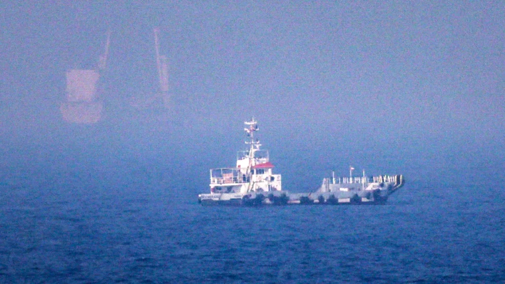 Why the US-Iran escalation over Hormuz will not be the last A small vessel navigating misty waters near the Strait of Hormuz, visually representing the ongoing maritime tensions central to the latest US-Iran escalation.
