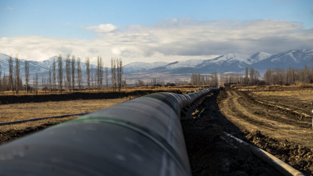 A ground-level view of the Trans Anatolian pipeline stretching across a rural Turkish landscape with mountains in the background, highlighting the infrastructure critical to Turkey's role as an energy gatekeeper.