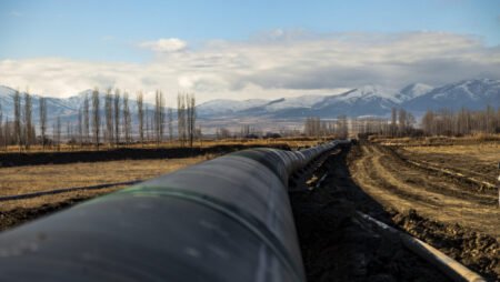 A ground-level view of the Trans Anatolian pipeline stretching across a rural Turkish landscape with mountains in the background, highlighting the infrastructure critical to Turkey's role as an energy gatekeeper.