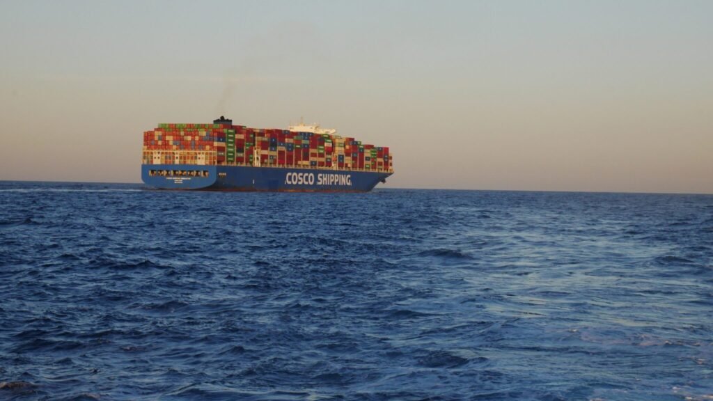 The COSCO Shipping container vessel navigating open waters along Red Sea maritime transit routes, representing commercial shipping risks associated with the Yemen Front.