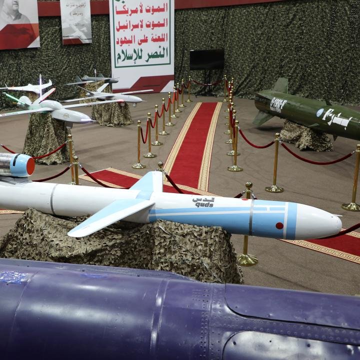 Counter-Drone Partnership Bolsters Gulf Ukraine Security A military exhibition displaying an Iranian "Quds" cruise missile and various unmanned aerial vehicles on a red carpet behind gold stanchions, visually representing the aerial threats that the new Counter-Drone Partnership aims to neutralize in order to bolster Gulf and Ukrainian security.