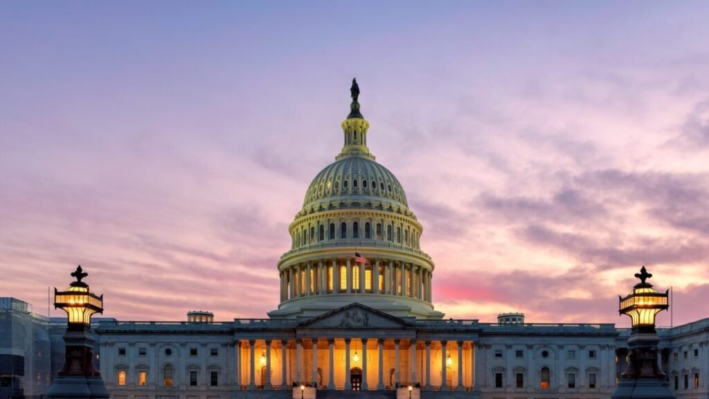 The United States Capitol Building stands illuminated against a vibrant sunset sky, symbolizing legislative gridlock in Washington as defense funding delays worsen the Munitions Crisis.