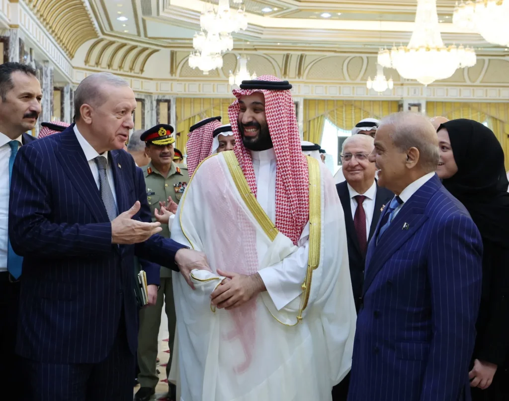 التحالفات الخليجية: صفقات الأسلحة تفشل في شراء الولاء Erdogan, MBS, and Shehbaz Sharif conversing at a diplomatic meeting, assessing arms deals and strategic Gulf alliances.