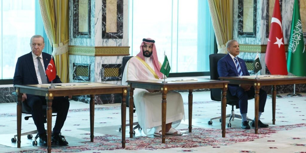 Turkish President Erdogan, Saudi Crown Prince Mohammed bin Salman, and Pakistani Prime Minister Sharif sit at signing desks with national flags in Mecca, underscoring regional defense realignments at the center of the Egypt Mecca Pact debate.