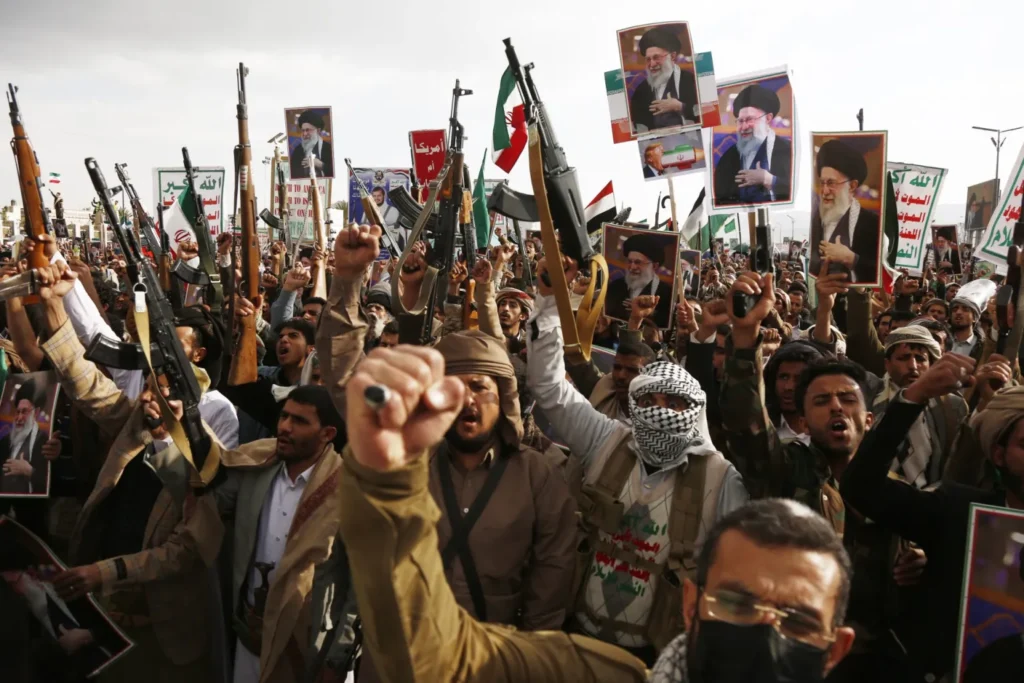 Armed pro-Iran demonstrators in Sana’a, Yemen, raise rifles and hold portraits of Ayatollah Khamenei during a rally, illustrating the regional proxy security challenges that directly impact Gulf Allies.