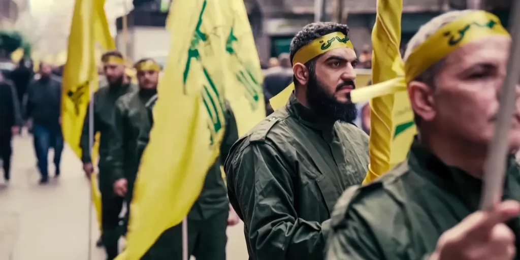 فانتزی لبنان ترامپ با واقعیت روبرو میشود Men in military-style fatigues wearing yellow headbands marching with flags during a rally, highlighting the complex political realities confronting US policy in Lebanon.