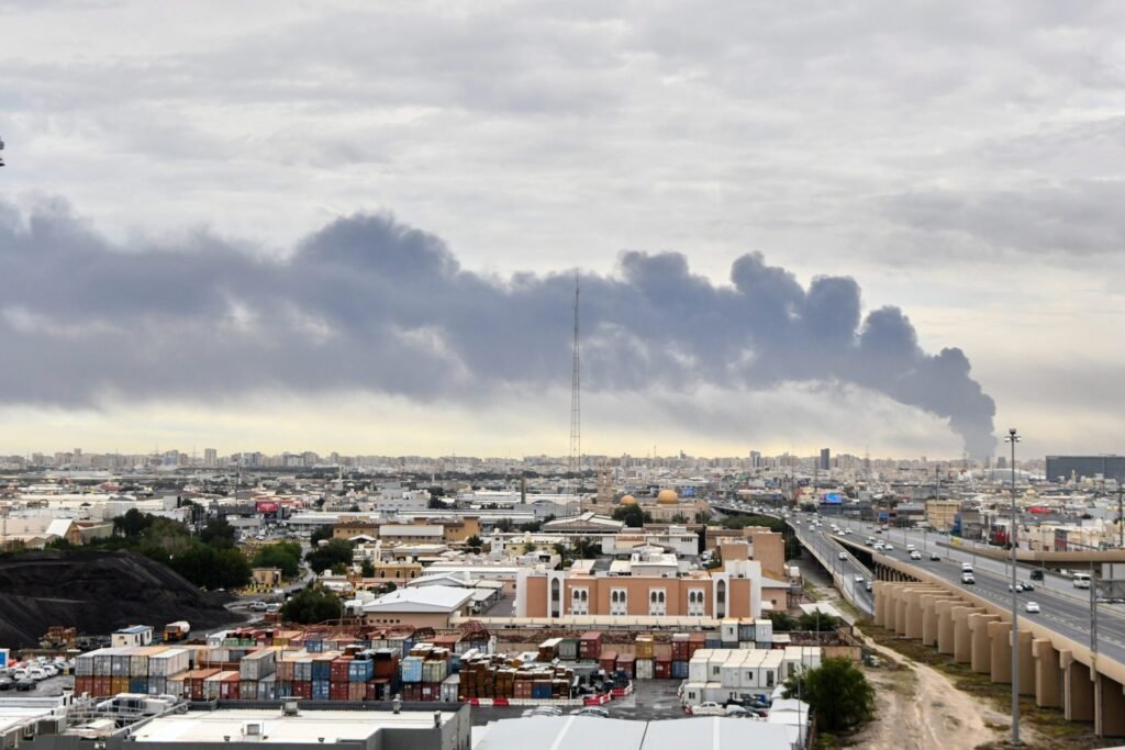 Plume of thick smoke rising over Kuwait City infrastructure after a strike, reshaping the Kuwait Defense Strategy.