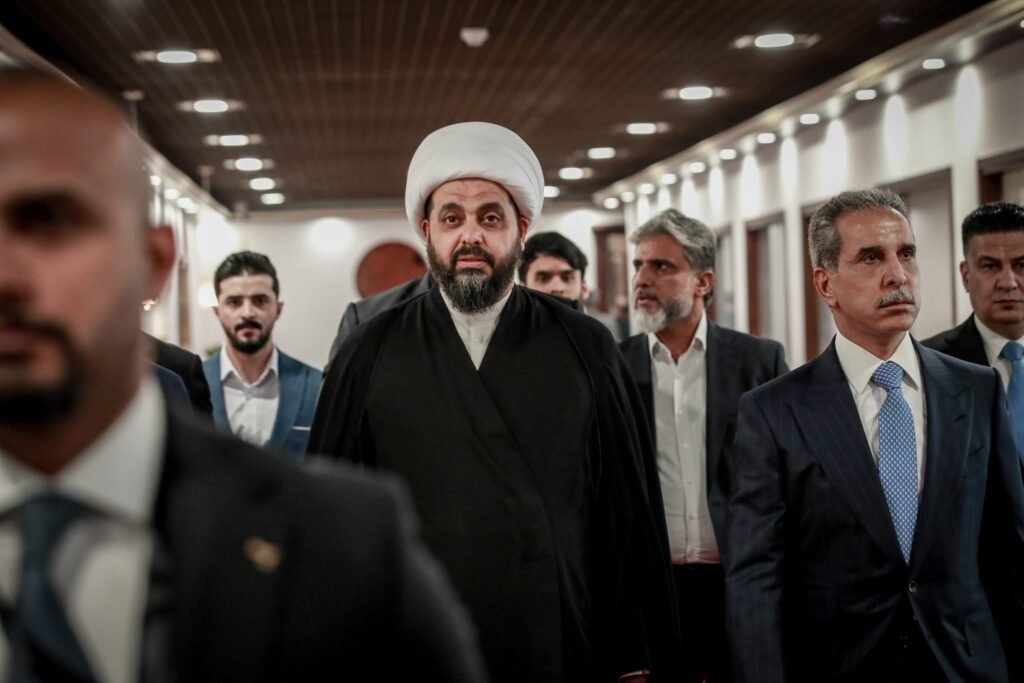 میلیشیاهای عراقی بقاء را بر مقاومت ترجیح میدهند Qais al-Khazali, leader of Asaib Ahl al-Haq, walking through the parliament building with associates, illustrating how Iraqi militias navigate political survival over armed resistance.