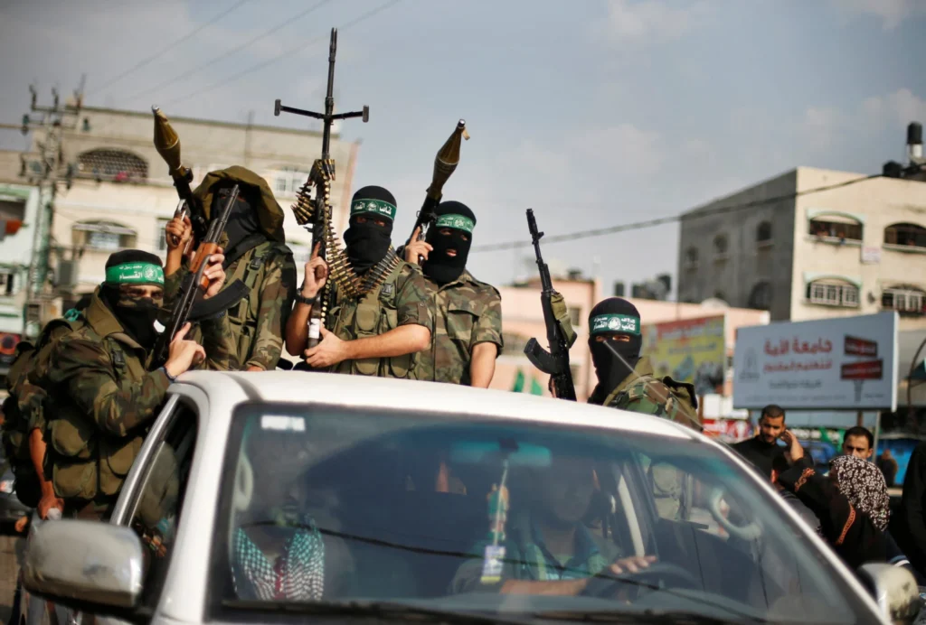صفقة نزع سلاح حماس تثير 10 أسئلة رئيسية Masked Hamas militants holding automatic weapons and RPGs in a vehicle, highlighting the security challenges surrounding any proposed Hamas Disarmament Deal.