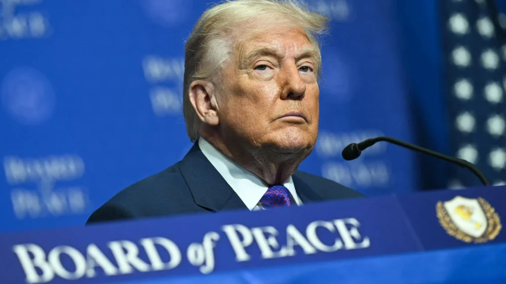 Gaza peace plan exposes strategic limits of disarmament Donald Trump seated behind a microphone at a Board of Peace podium, illustrating the diplomatic challenges surrounding the proposed Gaza peace plan.