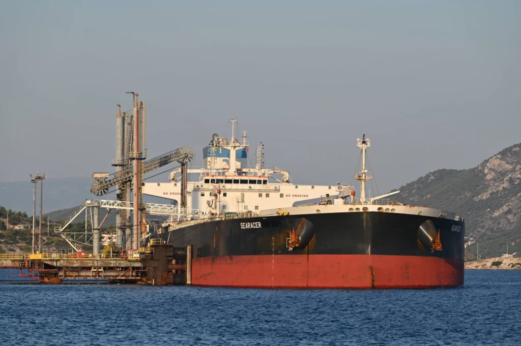 An oil tanker unloads crude oil at a port terminal, illustrating how global energy rerouting diminishes the strategic leverage of the Iran Strait of Hormuz.