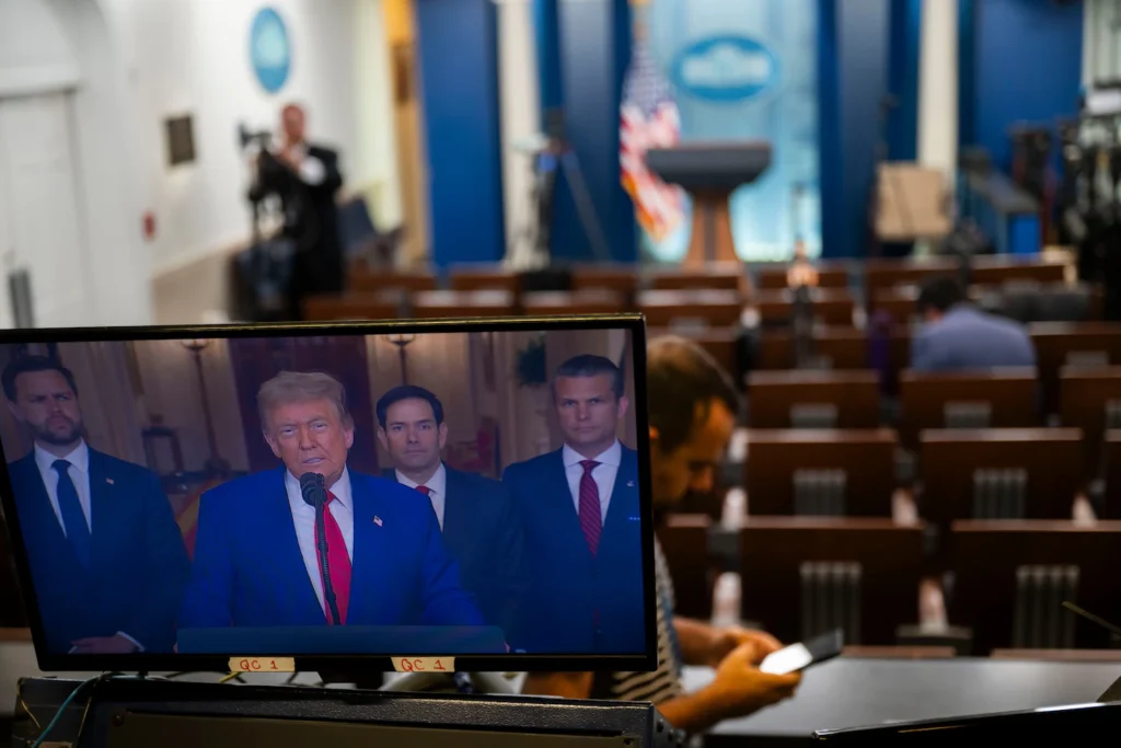 A broadcast monitor in the White House press room displays Donald Trump speaking alongside key advisers, illustrating media coverage surrounding the Trump Iran Leaks.