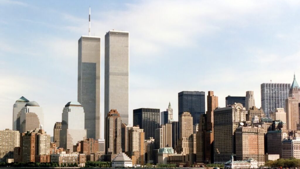 A historic photograph of the pre-9/11 New York City skyline showing the Twin Towers standing prominently under a clear blue sky, symbolizing the peaceful era before the attacks and underscoring the tragic failure to act on the 9/11 Warnings that were ignored for decades.