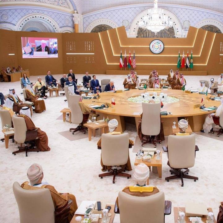 صفقة تسوية إيران: مذكرة تفاهم معدلة، وليست حربًا جديدة Gulf leaders in traditional robes and Western officials seated around a vast circular table beneath a crystal chandelier, with Saudi, Emirati, and American flags behind them, the diplomatic setting where an Iran Compromise Deal is being framed as a revised MOU, not a new war.