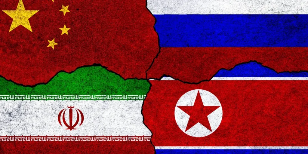 محور متجاوزان چالشهایی برای آمادگی دفاعی ایالات متحده ایجاد میکند A textured graphic collage of the flags of China, Russia, Iran, and North Korea interlocking like pieces of a fractured puzzle, symbolizing the geopolitical collaboration of the Axis Of Aggressors that poses a direct and complex challenge to US defense readiness.