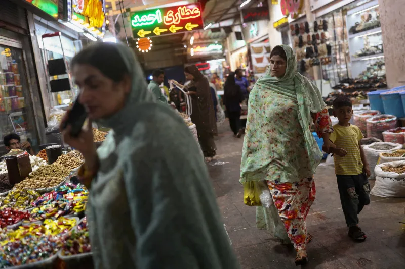 US-Iran Economic War Cannot Break a Regime Built to Endure A bustling local market in Bandar Abbas with women and a child shopping for nuts and sweets, illustrating how everyday life endures amid the US-Iran Economic War.