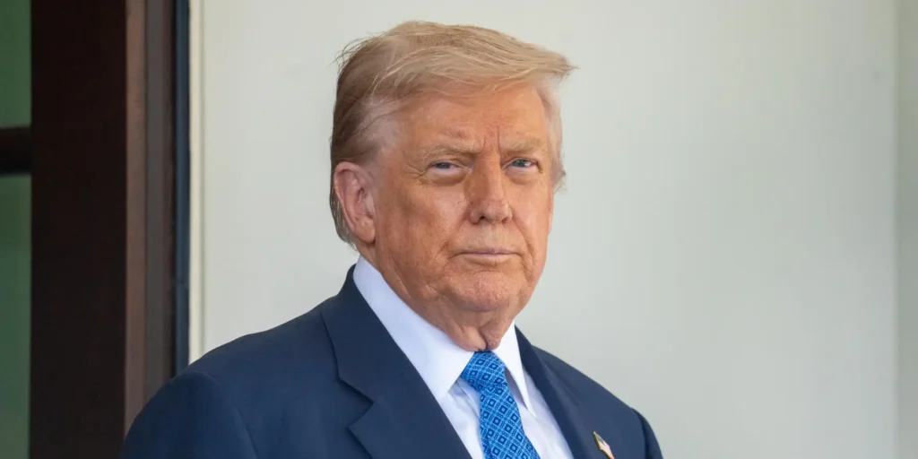 A stern-looking Donald Trump in a dark suit and blue tie stares ahead, illustrating the Iran Stalemate that leaves the US without any clear way out.