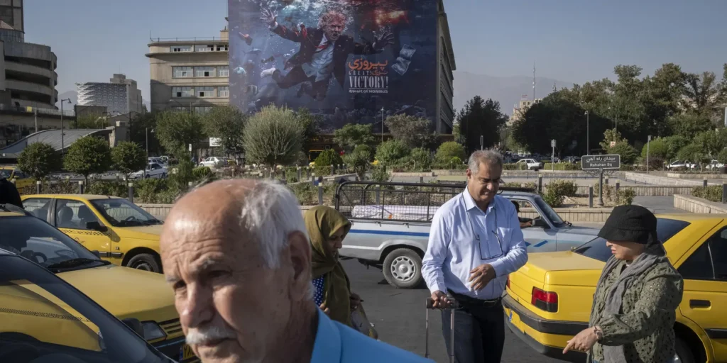 Why ‘D-Day’ was destined to be a dud A vibrant street scene in Tehran showing yellow taxis and pedestrians walking beneath a massive satirical billboard depicting Donald Trump flailing underwater with "GREAT VICTORY!" text, symbolizing the Iranian public's mocking response that underscores why the anticipated D-Day campaign was destined to be a dud, failing to disrupt daily life in the capital.